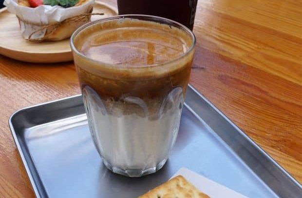 Glass of dirty coffee on tray