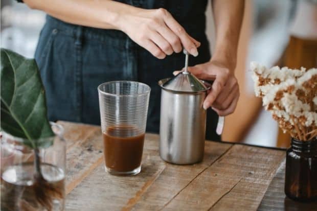 Person using manual milk frother instead of steamer.