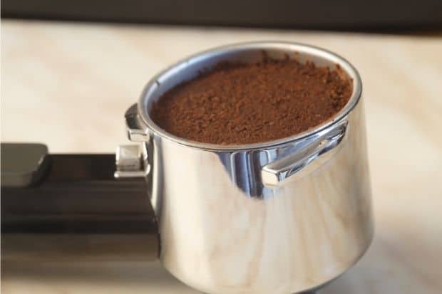 Portafilter filled with coffee grounds in test to determine if portafilter size does matter