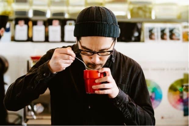 Man taste-testing coffee drink after learning how to get into coffee