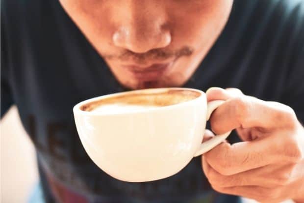 Man sniffing coffee drink after learning how to get into coffee