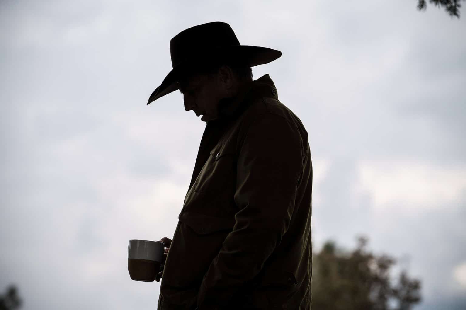 John Dutton in silhouette, holding his coffee mug
