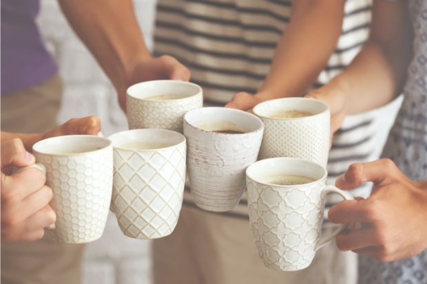 People clanking coffee mugs together after learning how to aerate coffee