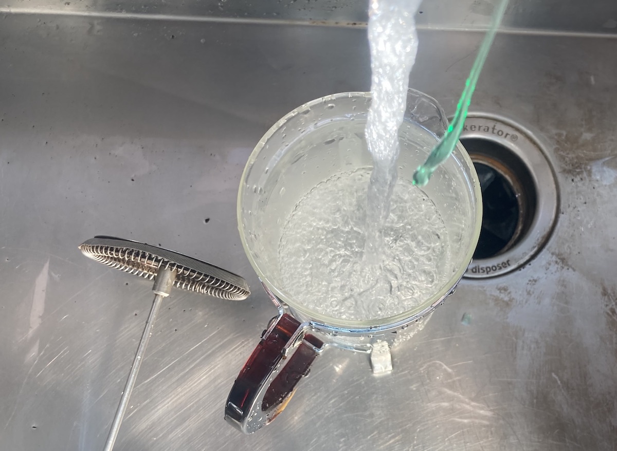 Soap being added to a French press during cleaning