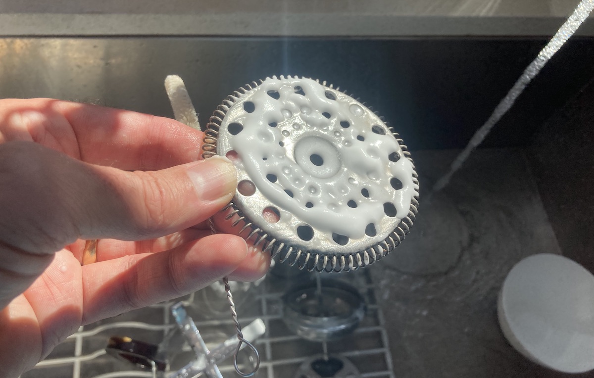 A paste of water and baking soda on the plunger of a French press