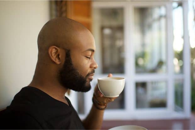 Man enjoying cup of coffee after roasting his own coffee
