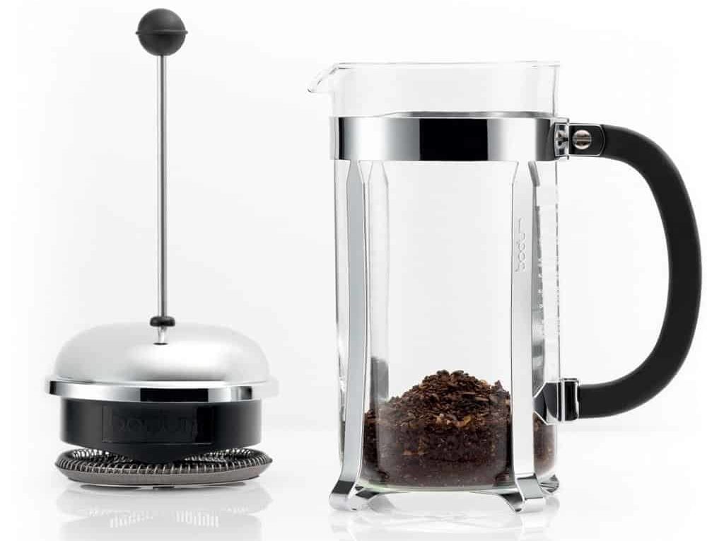 Side view of a glass bodum French press against a white background
