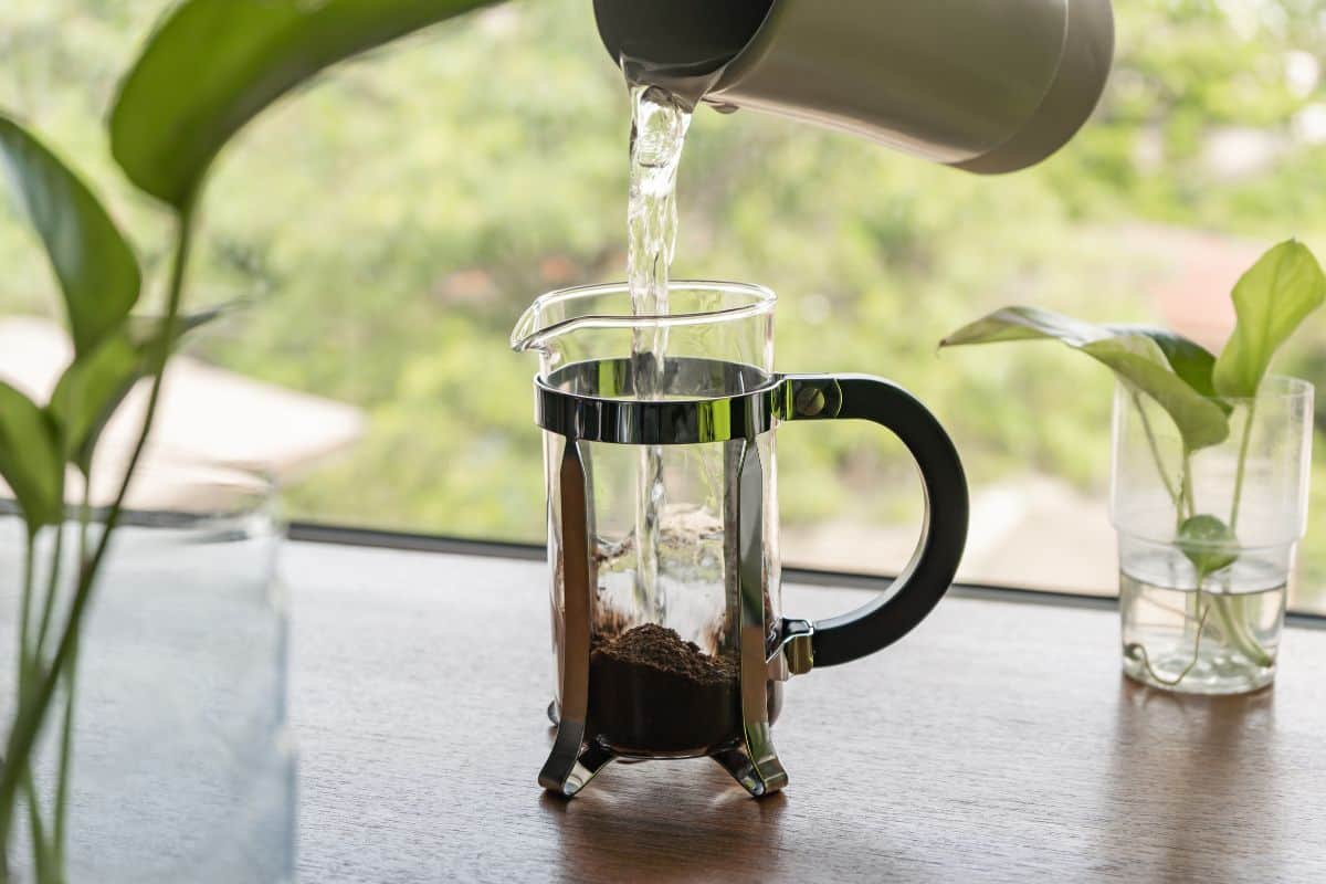 Water being poured from a jug into a French press