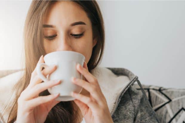 Woman tasting coffee with heavy whipping cream