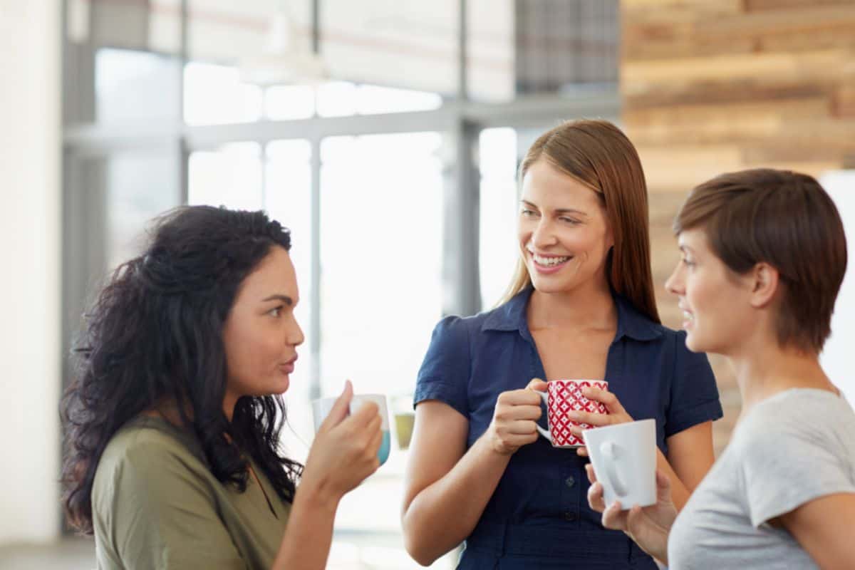 Three women drinking coffee in the office