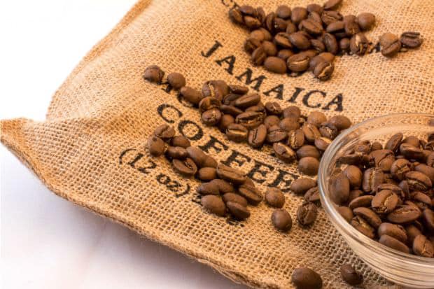 Coffee beans on a burlap sack labelled with the words Jamaica Coffee