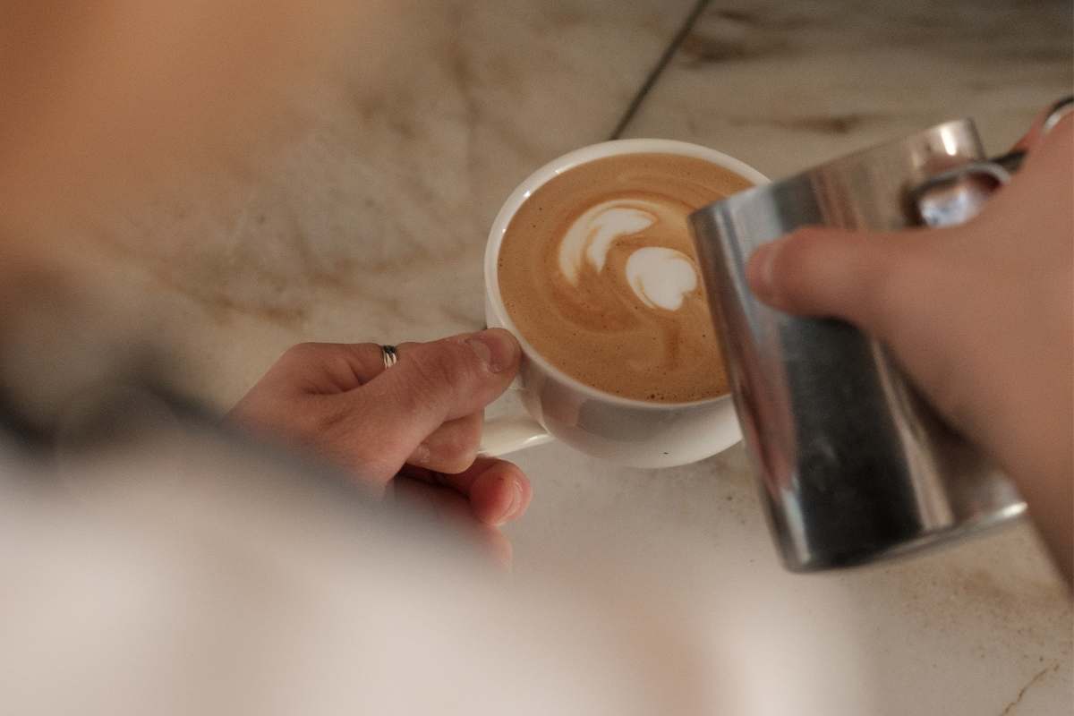 A latte artist at work on a design