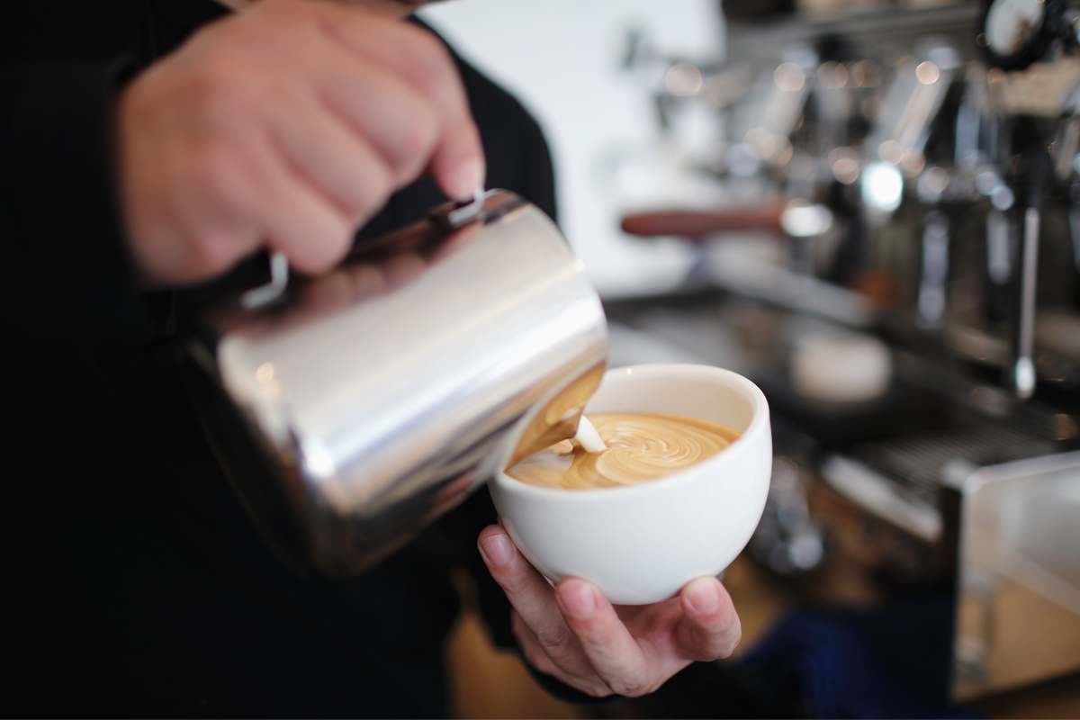 Barista patiently practicing his latte art