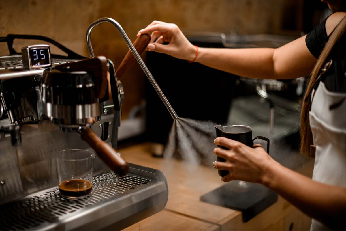 Barista purging a steam wand on an espresso machine
