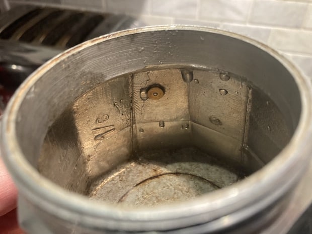 Closeup of inside of a moka pot showing water halfway to the top