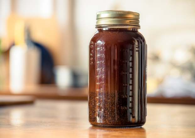 A closed jar of cold brew coffee steeping on a counter