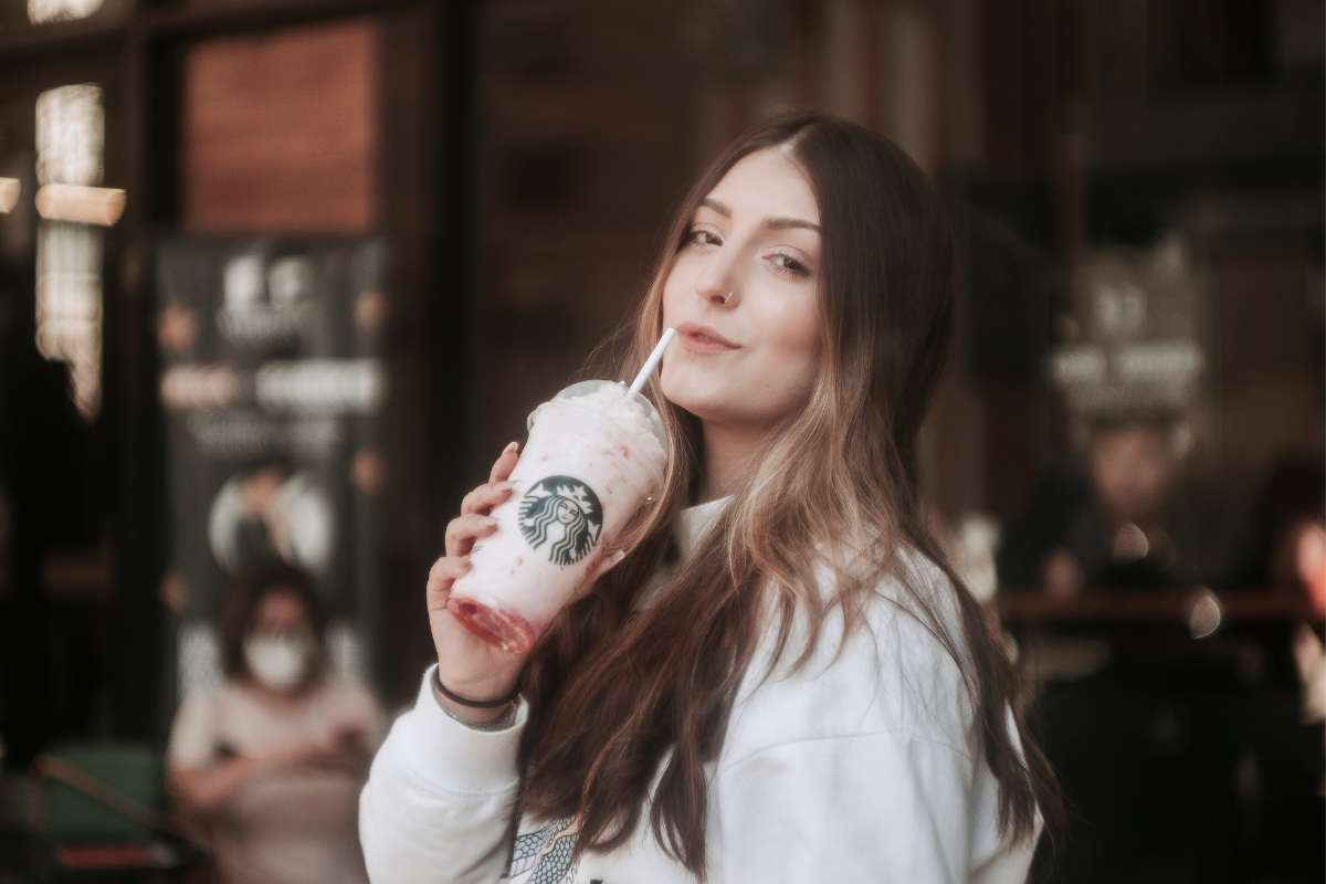 Woman enjoying a fancy pink drink from Starbucks