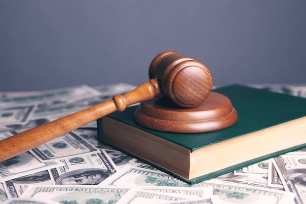 Gavel on top of a book on top of a pile of U.S. currency