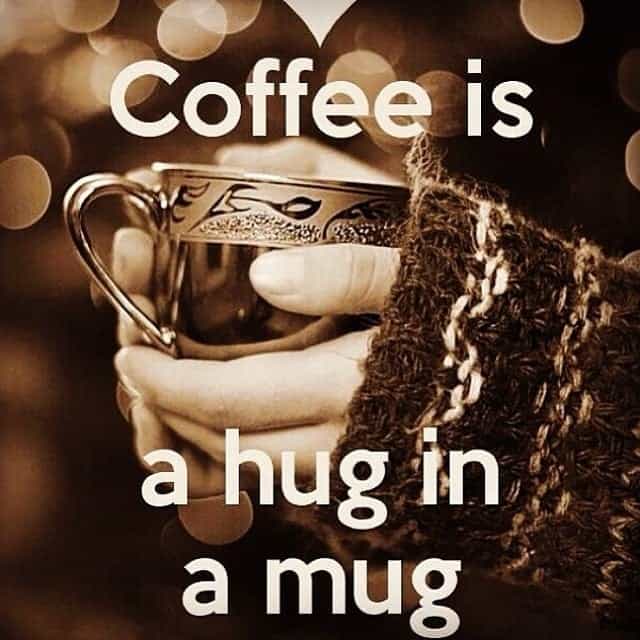 A pair of hands cradling a mug with the caption: Coffee is a hug in a mug.