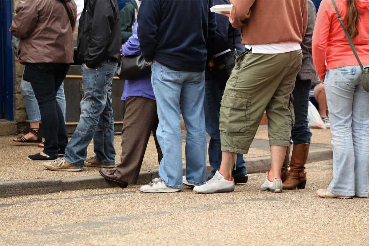 People on the street queue to get into a coffee shop