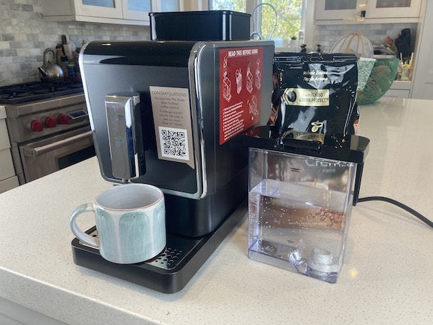 Tchibo coffee machine on a counter with water tank beside it