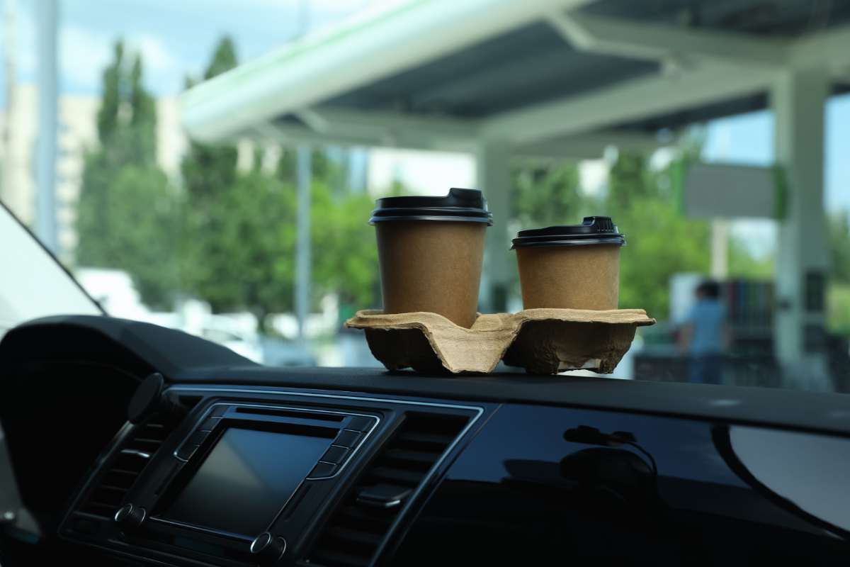Two coffees on car dashboard