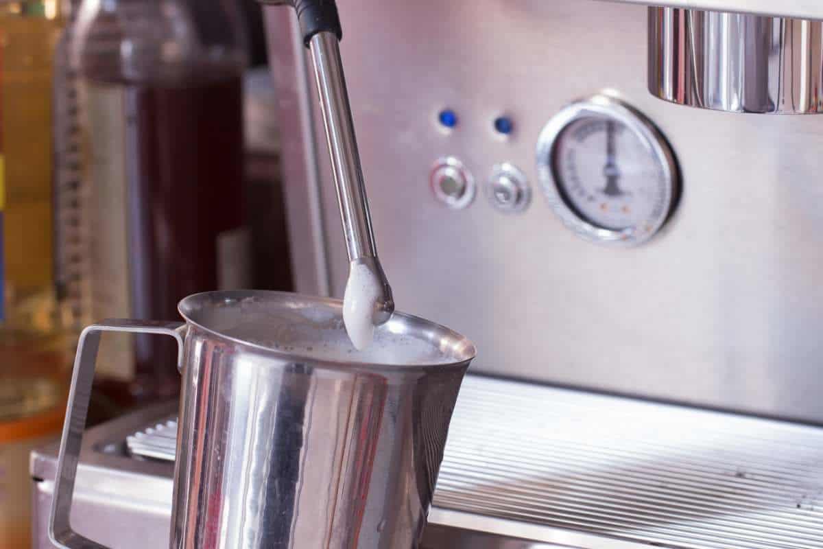 Frothed milk next to an espresso machine