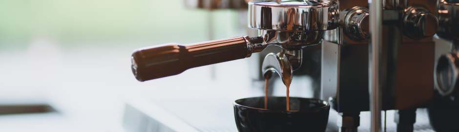 Espresso flowing from a portafilter into a cup