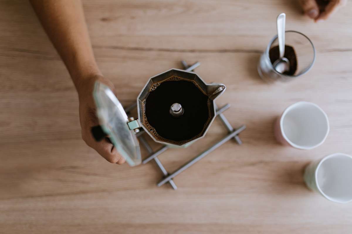 Overhead view of a person preparing moka pot coffee