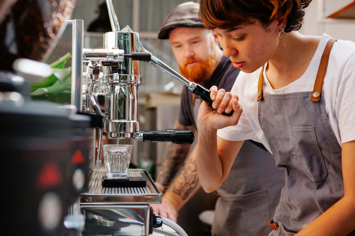 Barista pulling a lever on an espresso machine