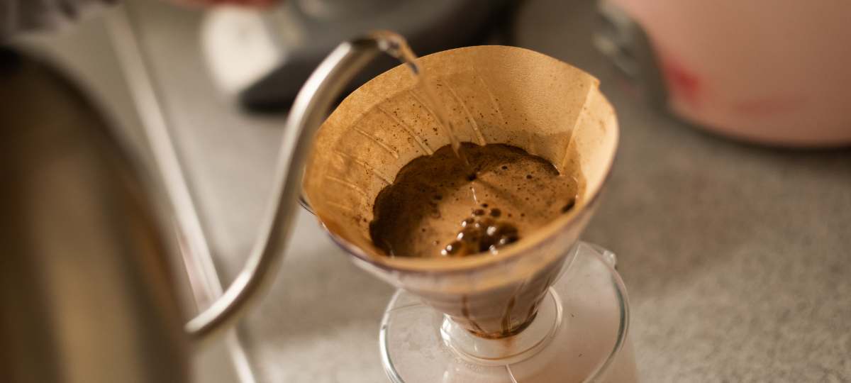 Gooseneck kettle pouring water into a pour over coffee cone