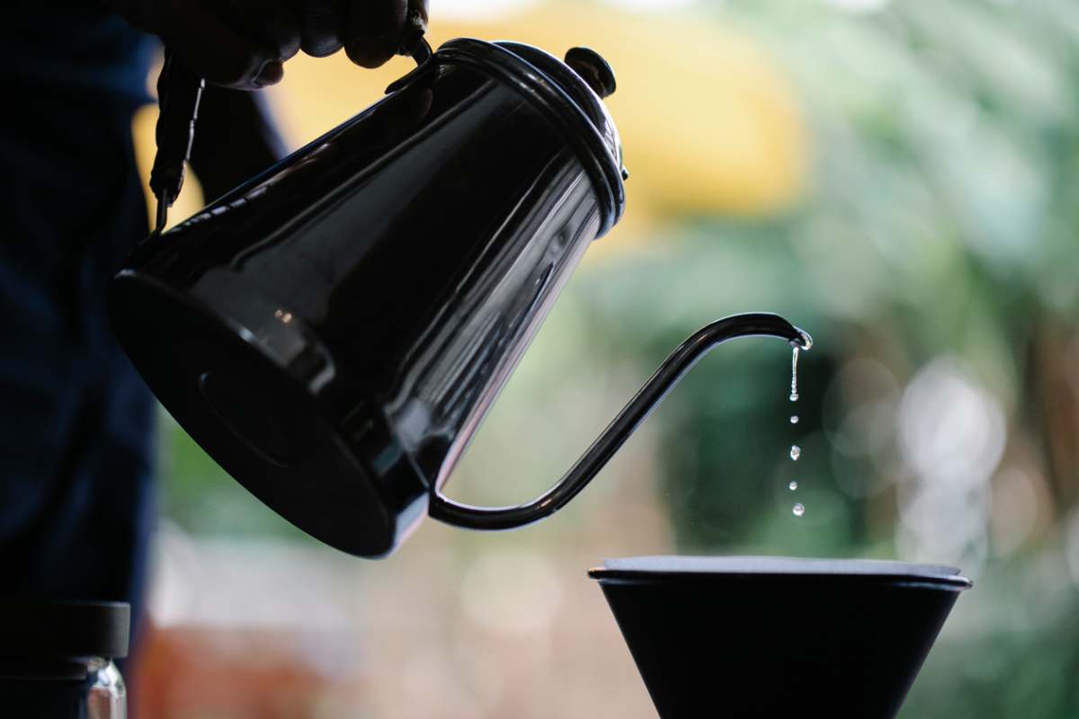 Water dripping from the goosneck on a kettle into a coffee filter cone